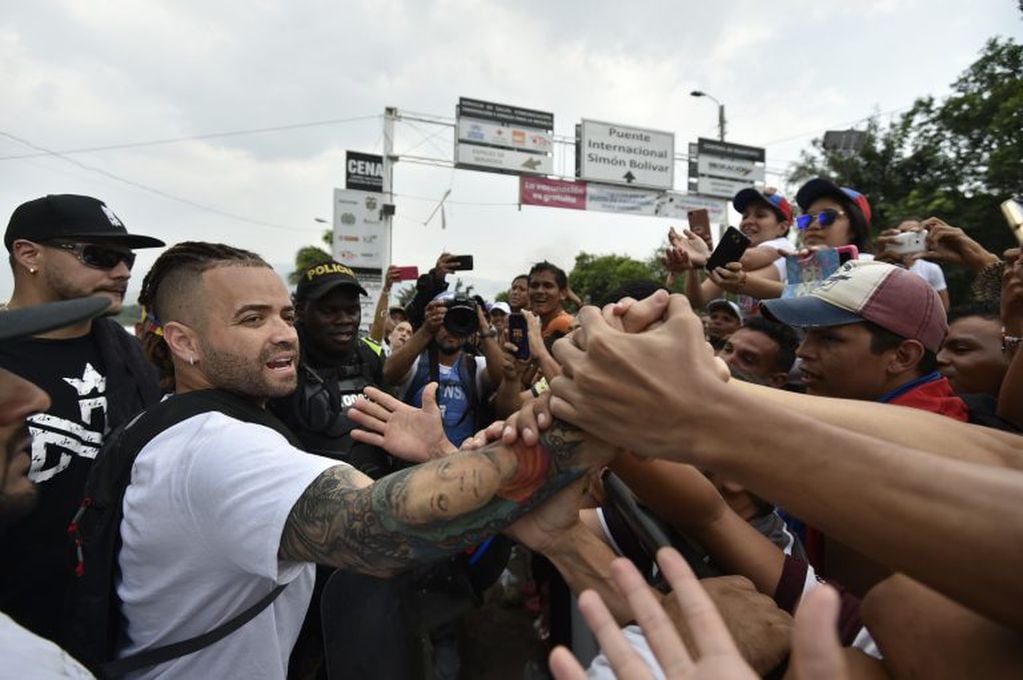 El cantante venezolano Nacho saluda a los partidarios del líder opositor venezolano Juan Guaido en el Puente Internacional Simón Bolívar en Cúcuta, Colombia. (Photo by Luis ROBAYO / AFP)