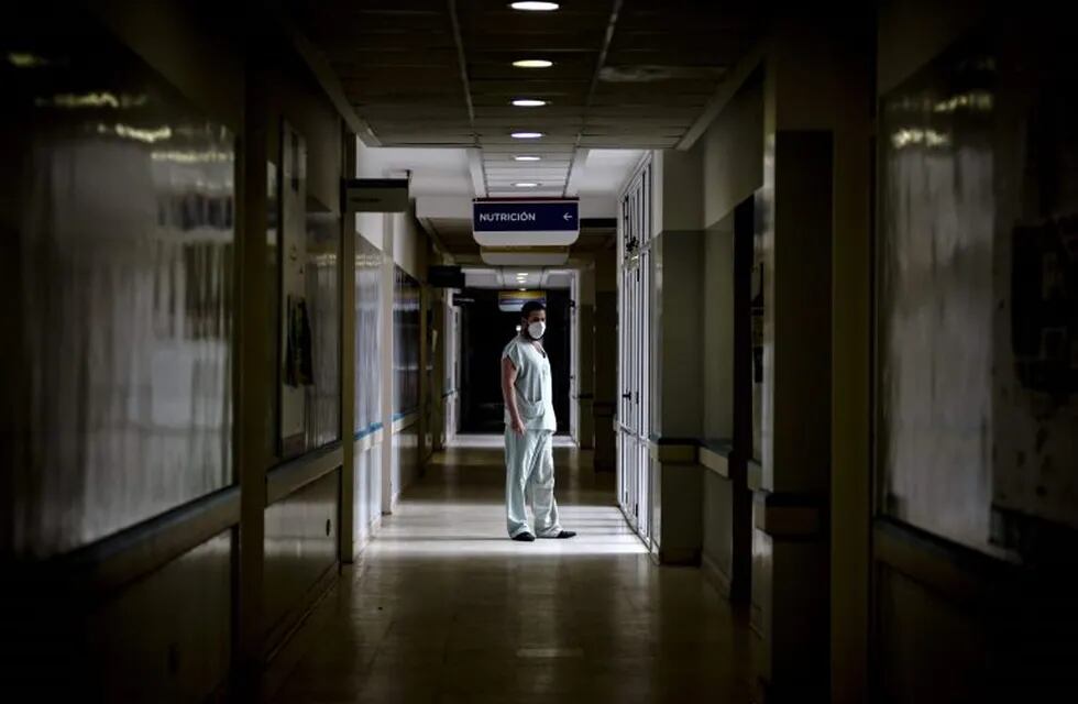 TOPSHOT - Dr Mario Grossmann poses for a photo during his 24hs shift, at the emergency area of the Doctor Alberto Antranik Eurnekian Public Hospital in Ezeiza, in the outskirts of Buenos Aires on August 29, 2020, amid the new coronavirus, COVID-19, pandemic. - Dr Grossmann, a professor, head of practical work of semiology and internal medicine at Buenos Aires University (UBA) and chair head of semiology and internal medicine at Universidad Abierta Interamericana (UAI) teaches from the hospital through video calls to students of 4th and 5th year. (Photo by ARIEL TIMY TORRES / AFP)