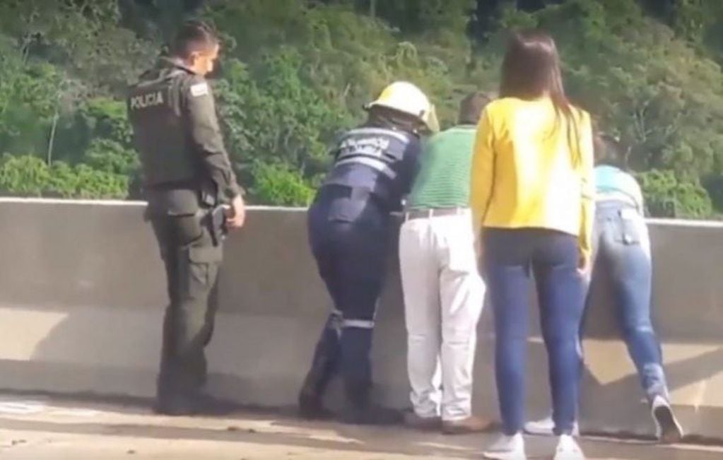 Personal de las Fuerzas de Seguridad colombiana y testigos intentan impedir que la mujer se tire