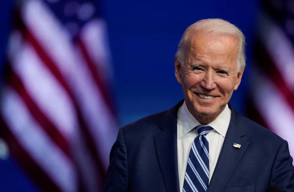 El presidente electo Joe Biden sonríe mientras habla en el teatro Queen en Wilmington.