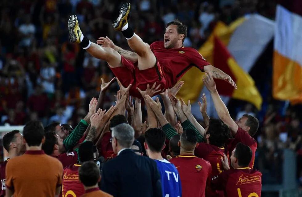 AS Roma players celebrate Roma's captain Francesco Totti during a ceremony following his last match with AS Roma after the Italian Serie A football match AS Roma vs Genoa on May 28, 2017 at the Olympic Stadium in Rome. Italian football icon Francesco Totti retired from Serie A after 25 seasons with Roma, in the process joining a select group of 'one-club' players. / AFP PHOTO / Vincenzo PINTO