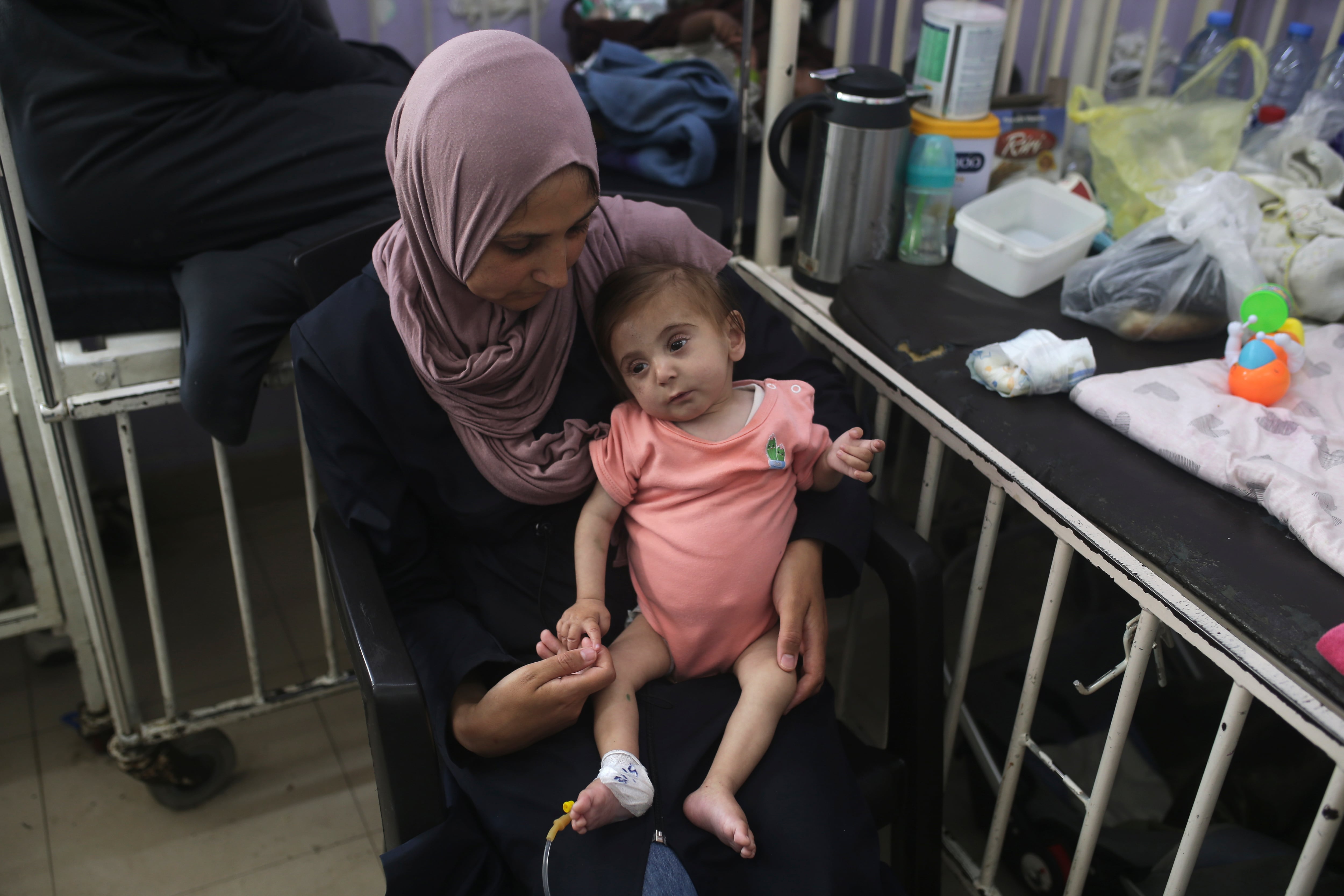 Amira Al-Jojo carga a su hijo Al-Jojo, de 10 meses, que sufre de desnutrición, en el hospital Al-Aqsa Martyrs Hospital, en donde está siento atendido, en Deir al-Balah, en el centro de la Franja de Gaza, el sábado 1 de junio de 2024. (AP Foto/ Jehad Alshrafi)