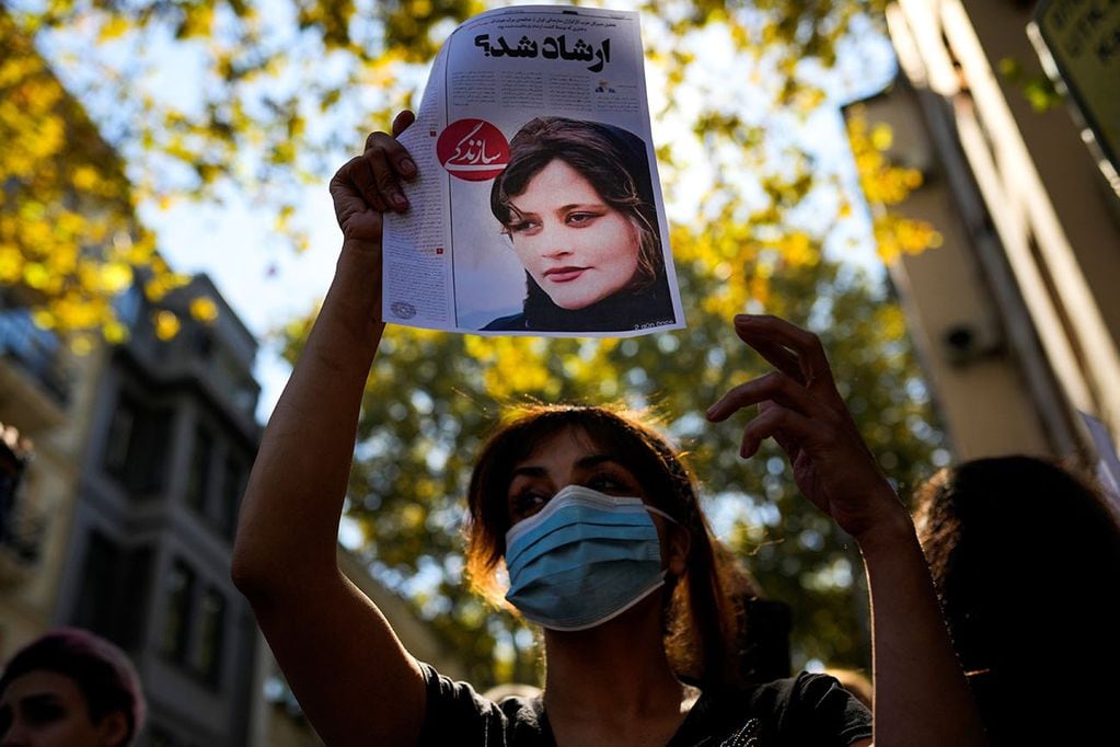 Una mujer sostiene una copia de un artículo de periódico con la foto del iraní Mahsa Amini que dice en persa: "¿Era Ershad?" durante una protesta contra la muerte de Amini, frente al consulado general de Irán en Estambul, Turquía. Foto AP