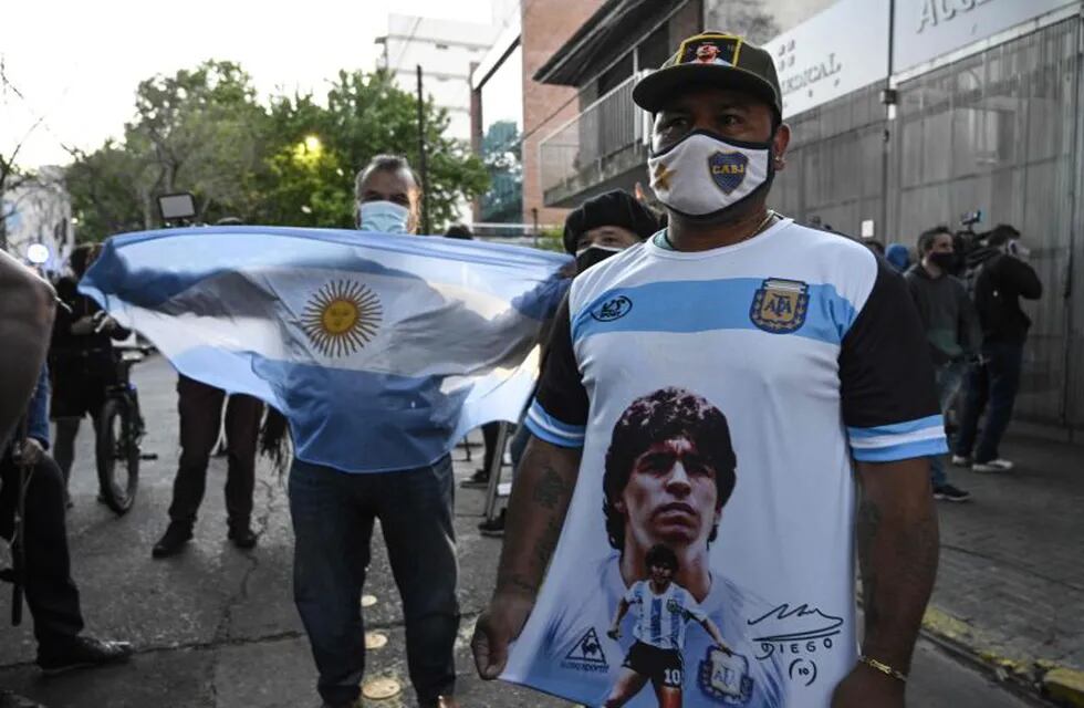 TOPSHOT - Supporters of Argentine former football star and coach of Gimnasia y Esgrima La Plata Diego Maradona gather outside the hospital where he will undergo brain surgery for a blood clot, in Olivos, Buenos Aires province, on November 3, 2020. (Photo by JUAN MABROMATA / AFP)