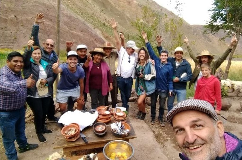 René Calpanchay, en la fotografía primero desde la izquierda, con turistas en una experiencia de cocina al aire libre en Purmamarca.