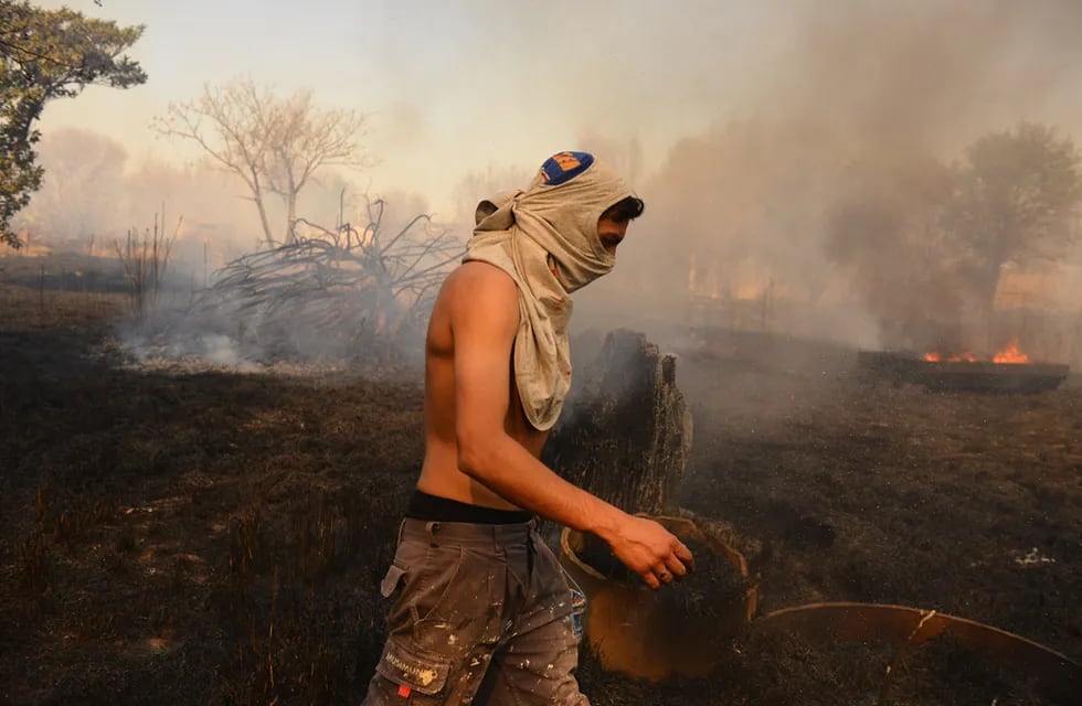 Incendio en una vivienda en Chacras de la Merced. Vecinos combaten las llamas que llegaron a una casa. (José Gabriel Hernández)