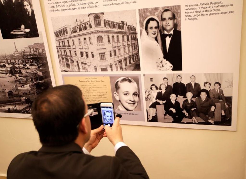 A visitor takes a picture of Jorge Bergoglio as a child during an exhibition on the migration of Italians to Argentina, including Pope Francis' family, at the Italian-Latin American Institute, in Rome, Friday, April 21, 2017. (AP Photo/Alessandra Tarantin