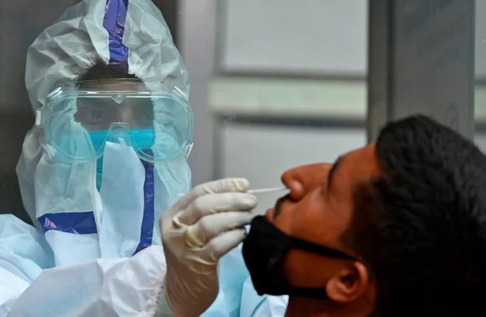 A health worker takes a swab sample from a man to test for the COVID-19 coronavirus at a testing centre in Srinagar on July 17, 2020. - EU leaders met face to face on July 17 to try to rescue Europe's economy from the ravages of the coronavirus pandemic, as India became the third country to record one million cases, joining Brazil and the United States. (Photo by TAUSEEF MUSTAFA / AFP)