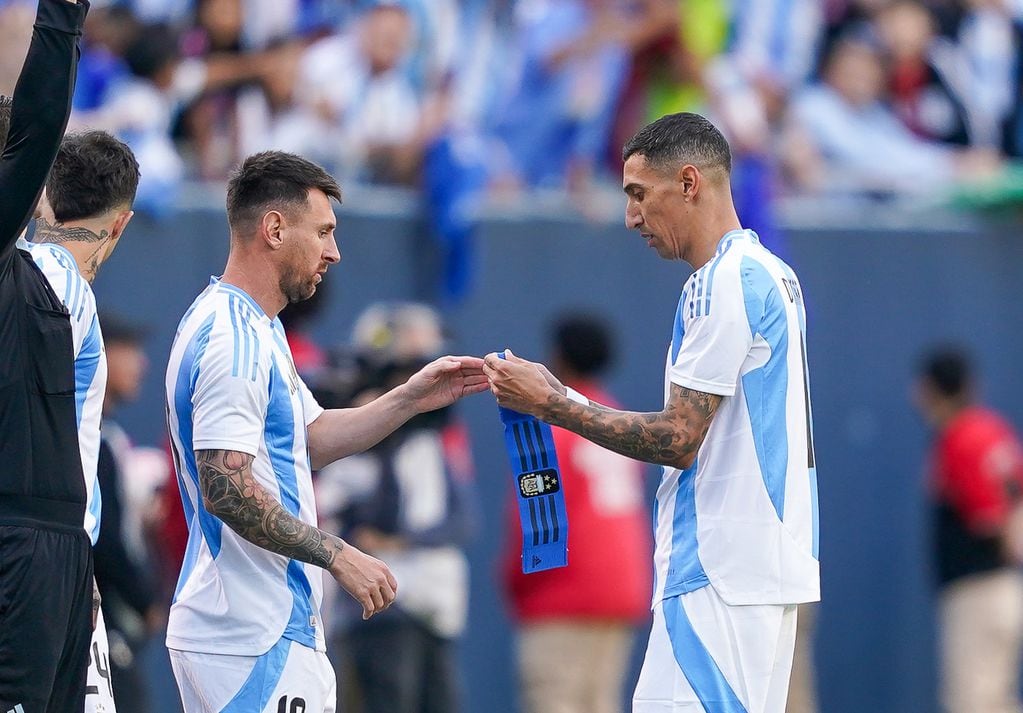 Di María le da la cinta de capitán a Messi en el partido ante Ecuador. (Prensa Argentina)