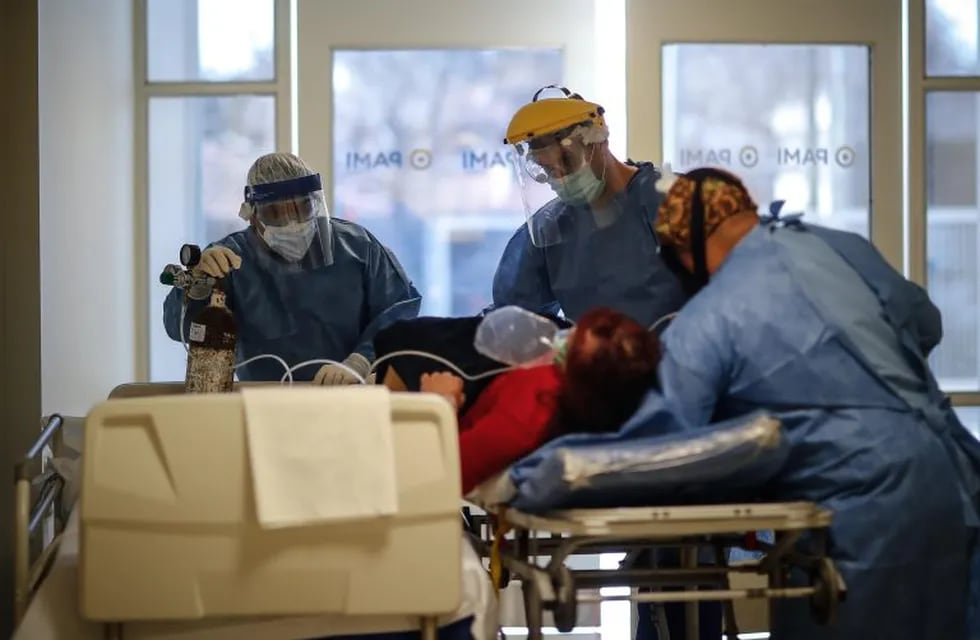 Personal médico traslada en camilla a una paciente covid-19 en el Hospital del Bicentenario de Esteban Echeverria. (Foto: EFE/ Juan Ignacio Roncoroni)