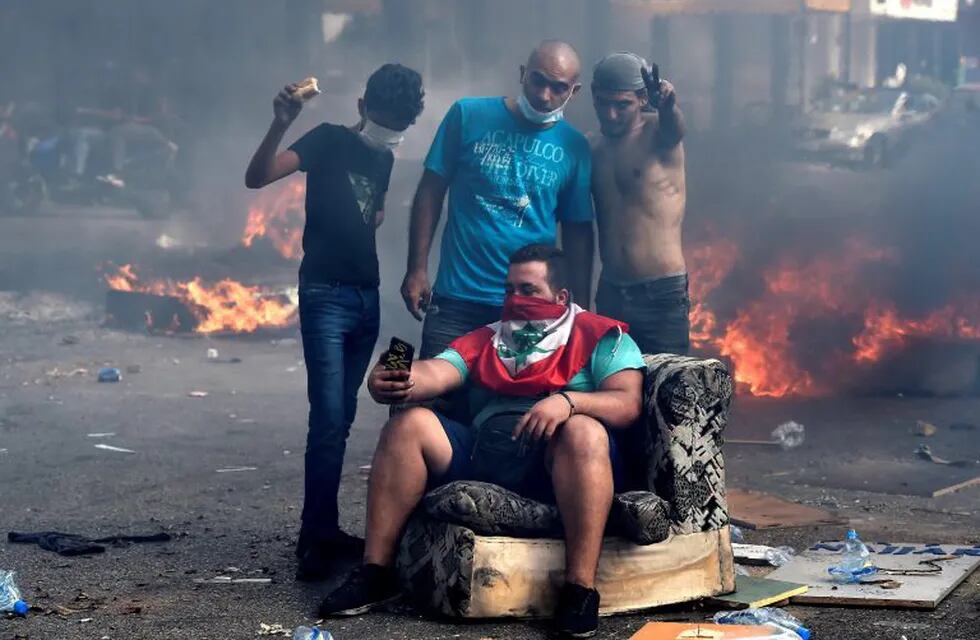 Beirut (Lebanon), 18/10/2019.- Protesters take a selfie by cell phone as they block the Dora highway by a fire of plastic barriers and trash during a protest in north of Beirut, Lebanon, 18 October 2019. Protesters, mainly civil activists, started to demonstrate in downtown Beirut on 17 October, condemning the proposed taxes that would go along with the 2020 budget, especially an unexpected government plan to impose a fee of 0.20 cents a day for using WhatsApp calls. This charge will not make it through the government palace according to the Telecommunications Minister Mohamed Choucair after witnessing the impact this made on the streets. (Protestas, Incendio, Líbano) EFE/EPA/WAEL HAMZEH