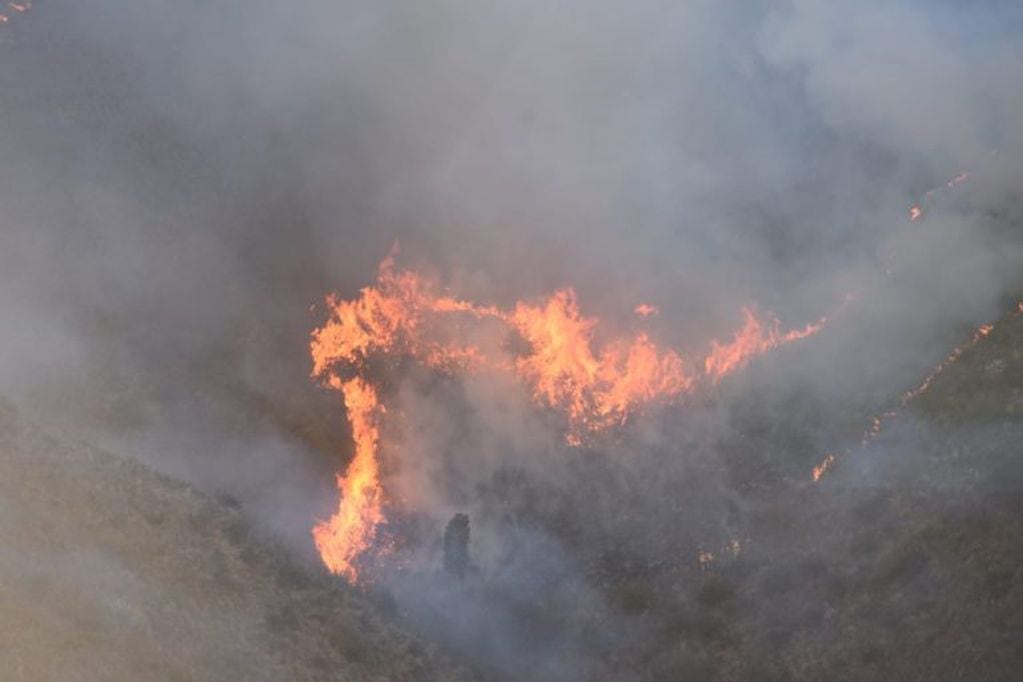 El incendio en La Falda, en el cerro La Banderita, sigue activo este lunes.