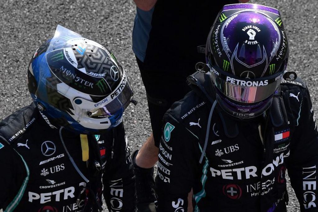 Hamilton (a la derecha) conversa con su compañero del equipo Mercedes, Bottas, tras la carrera. Esta vez, debieron contentarse con completar el podio.