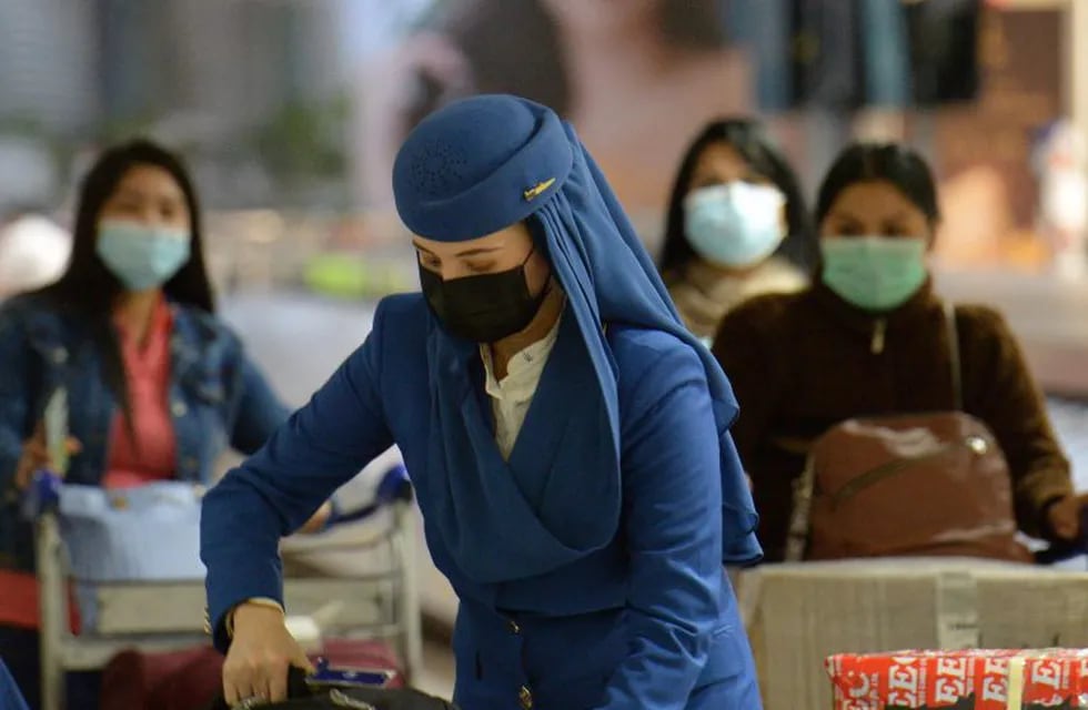 Arriving passengers and airline crew wear protective masks at the international airport in Manila on February 3, 2020. - The Philippines on February 2 reported the first death from the new coronavirus outside mainland China, as China said February 3 it urgently needed medical equipment and surgical masks as the death toll jumped above 360, making it more deadly than the SARS crisis nearly two decades ago. (Photo by Ted ALJIBE / AFP)