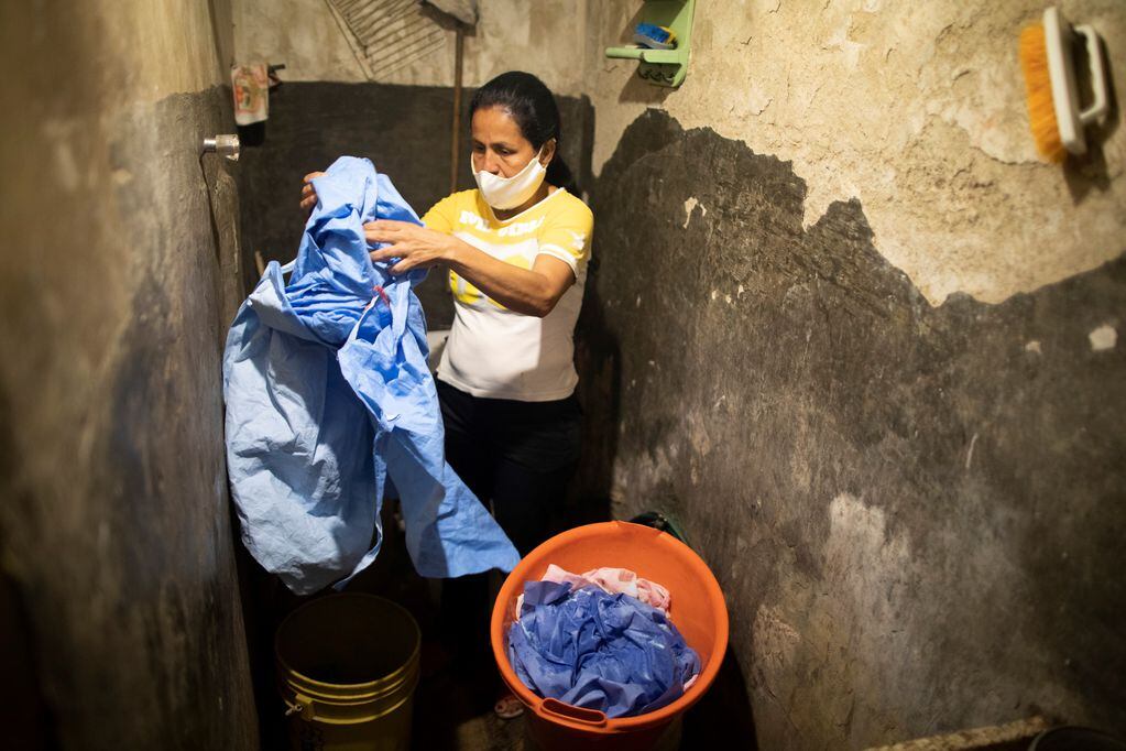 Una mujer lava la ropa en su baño en Caracas, Venezuela