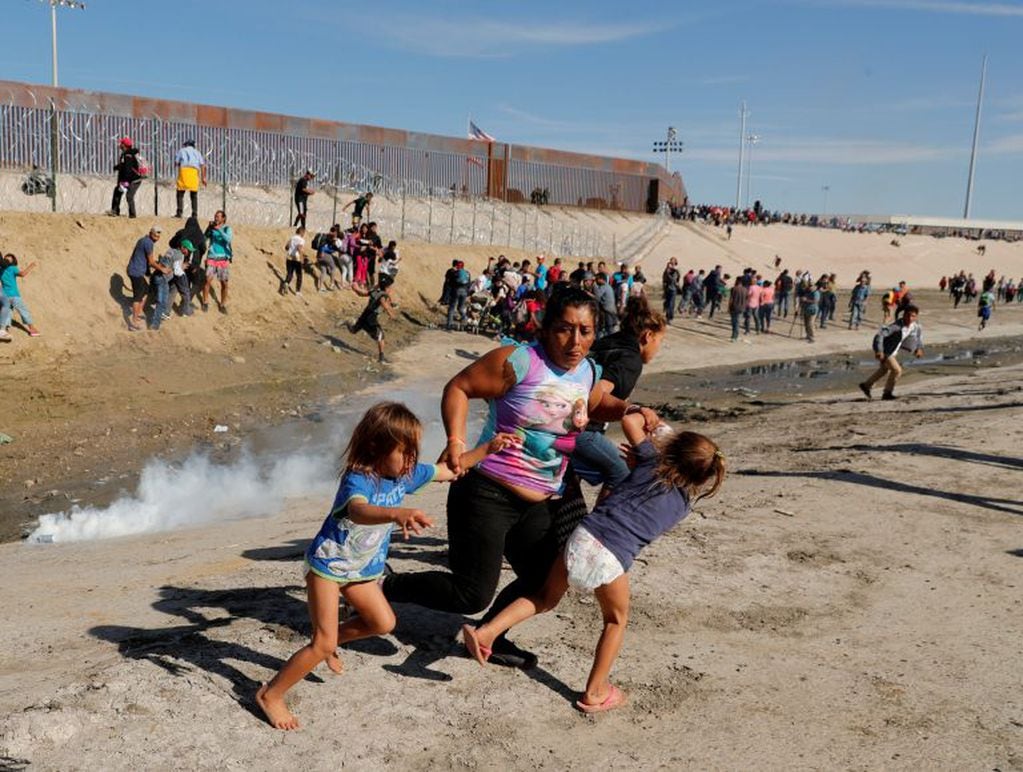 Una familia inmigrante escapa de los gases lacrimógenos que lanzan desde la frontera estadounidense hacia la ciudad fronteriza de Tijuana. Foto: Reuters/ Kim Kyung-Hoon.