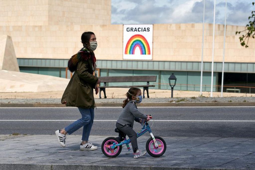 Una mujer pasea con una niña junto al Palacio de Congresos y Exposiciones Lienzo Norte en Ávila, este domingo.(Foto: EFE/ Raúl Sanchidrián)