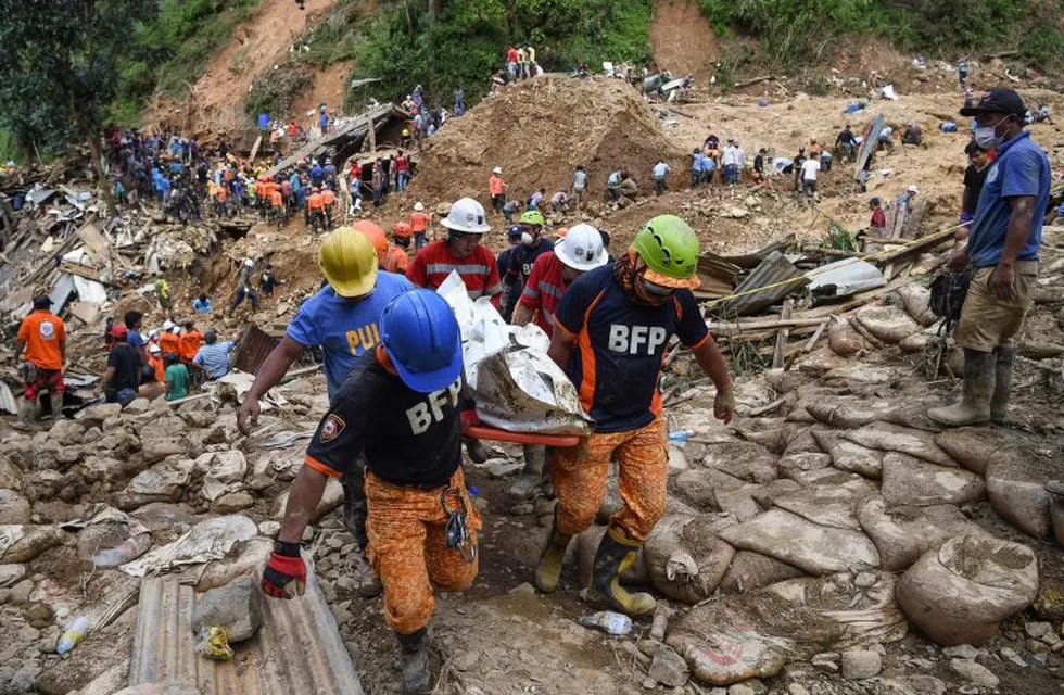Rescuers carry a body bag containing a landslide victim, triggered by heavy rains during Typhoon Mangkhut, in Itogon, Benguet province on September 18, 2018. - Hundreds of Philippine rescuers used shovels and their bare hands on September 18 to sift through a massive landslide, with dozens feared dead in the region worst-hit by Typhoon Mangkhut as the storm's toll climbed to 74. (Photo by TED ALJIBE / AFP)