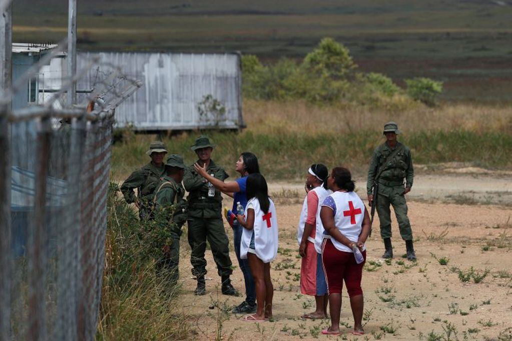 Voluntarios ofrecen agua a soldados venezolanos, en Pacaraima, Brasil, punto limítrofe con Venezuela.  REUTERS/Ricardo Moraes