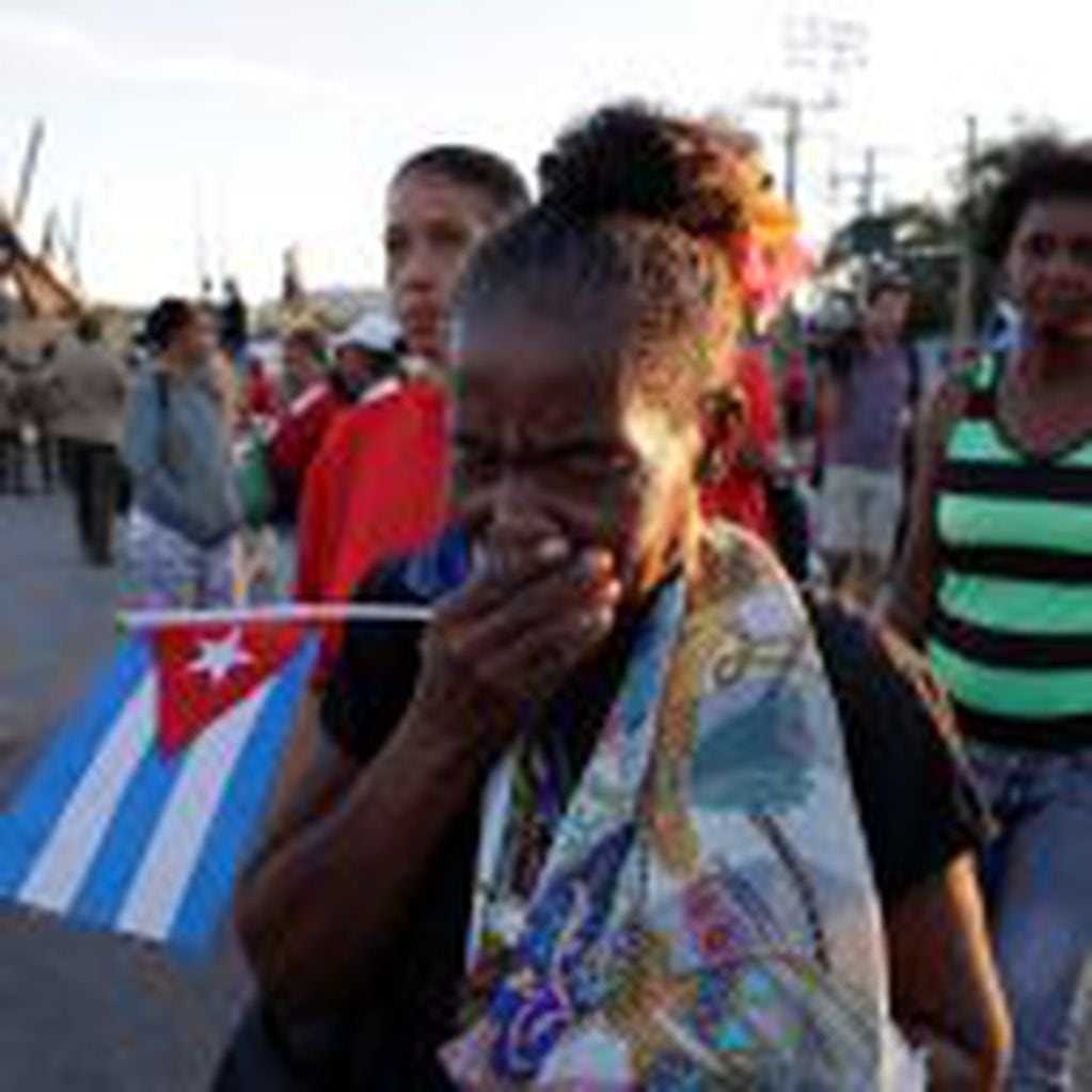 A woman cries after watching the ashes of Fidel Castro leave the Antonio Maceo plaza heading to the Santa Ifigenia cemetery for a private funeral ceremony in Santiago, Cuba, , Sunday, Dec. 4, 2016.(AP Photo/Natacha Pisarenko)