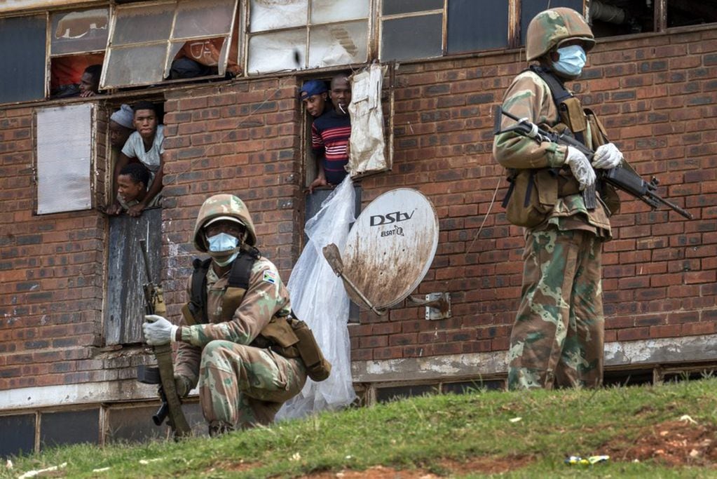 Fuerzas de Defensa Nacional de Sudáfrica patrullan el albergue de hombres en el densamente poblado municipio de Alexandra al este de Johannesburgo (Foto AP / Jerome Delay)