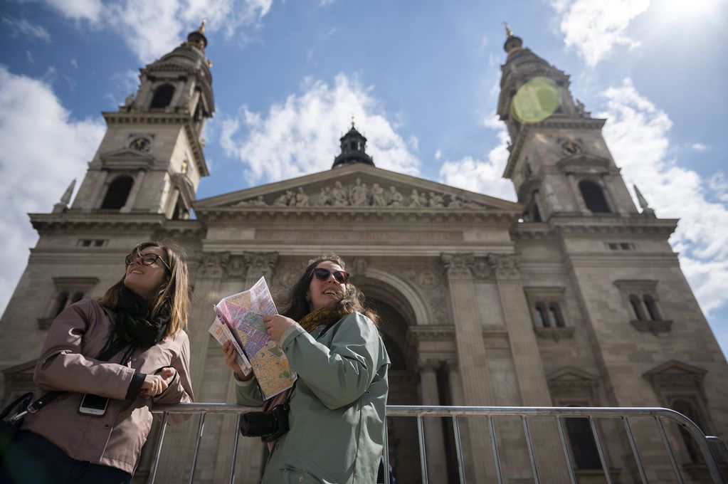 Turistas, junto a la Basílica de San Esteban, en Budapest el 27 de abril de 2023, donde el papa Francisco se reunirá con obispos, sacerdotes y trabajadores pastorales durante su visita de tres días a Hungría. (AP Foto/Denes Erdos)