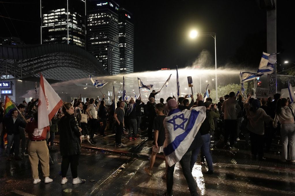 La policía usa cañones de agua para dispersar a manifestantes antigubernamentales en Tel Aviv, Israel, el lunes 27 de marzo de 2023. Decenas de miles protestaron el lunes contra la campaña del primer ministro israelí, Benjamin Netanyahu, por un plan de reforma judicial (AP)
