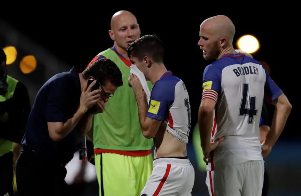 United States' Christian Pulisic, center, and his teammate United States' Michael Bradley, right, walk on the pitch after losing 2-1 against Trinidad and Tobago during a 2018 World Cup qualifying soccer match  in Couva, Trinidad, Tuesday, Oct. 10, 2017. (AP Photo/Rebecca Blackwell)