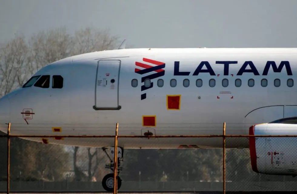 (FILES) In this file photo taken on May 26, 2020, a Latam airlines plane sits on the tarmac at Santiago International Airport, in Santiago, during the new coronavirus, COVID-19, pandemic. - The Chilean-Brazilian airline LATAM announced on June 17 that its subsidiary in Argentina will cease operations for an indefinite period, because in a pandemic scenario its operations are not viable. (Photo by MARTIN BERNETTI / AFP)