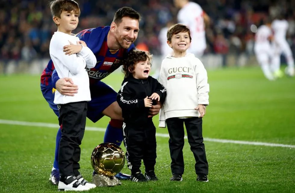 Barcelona's Lionel Messi, with his children, poses with his sixth Golden Ball for the best player of the year that he was awarded earlier in the week, before a Spanish La Liga soccer match between Barcelona and Mallorca at Camp Nou stadium in Barcelona, Spain, Saturday, Dec. 7, 2019. (AP Photo/Joan Monfort)
