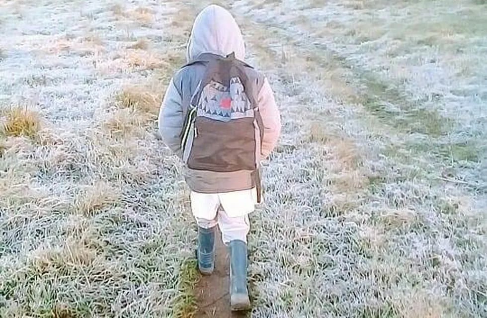 Un niño camina por la helada para llegar a la escuela