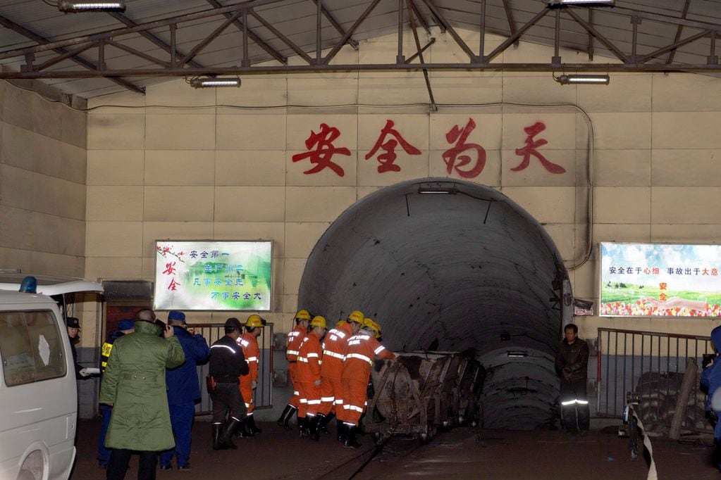 Los equipos de rescate buscan víctimas de un deslizamiento de tierra que enterró una mina de mineral de hierro en Xinyuan
