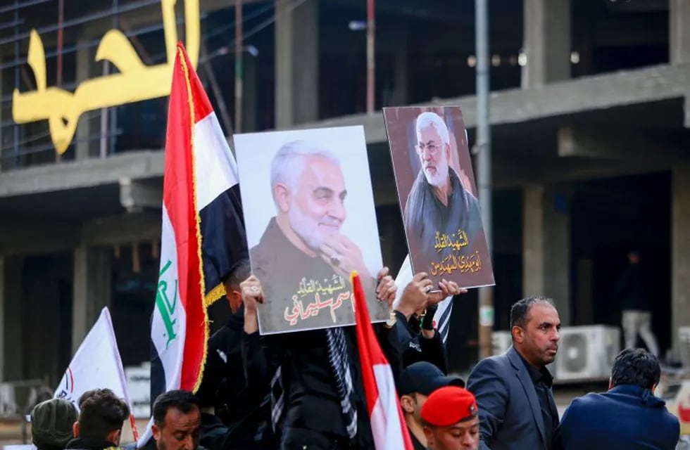 Mourners carry the portraits of Iranian military commander Qasem Soleimani and Iraqi paramilitary chief Abu Mahdi al-Muhandis, both killed in a US air strike, during a funeral procession in Kadhimiya, a Shiite pilgrimage district of Baghdad, on January 4, 2020. - Thousands of Iraqis chanting \