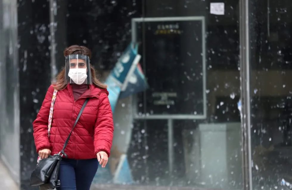 A woman wearing a face mask as a protective measure against the coronavirus disease (COVID-19) walks past a closed currency exchange shop, in downtown Buenos Aires, Argentina May 22, 2020. REUTERS/Agustin Marcarian