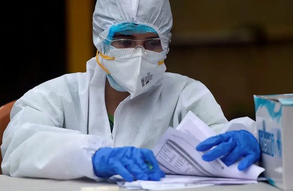 A medical representative prepares to collect swab samples from residents to test for the Covid-19 Coronavirus, in a residential area in Mumbai, on September 14, 2020. (Photo by Punit PARANJPE / AFP)