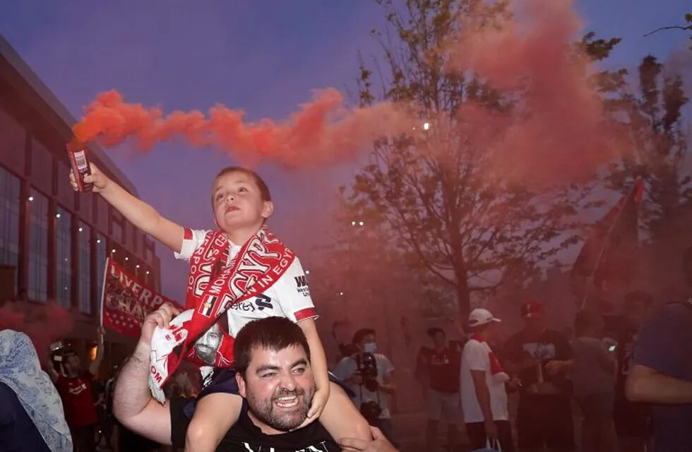 Liverpool supporters celebrate as they gather outside of Anfield Stadium in Liverpool, England, Thursday, June 25, 2020 after Liverpool clinched the English Premier League title. Liverpool took the title after Manchester City failed to beat Chelsea on Wednesday evening. (AP photo/Jon Super)
