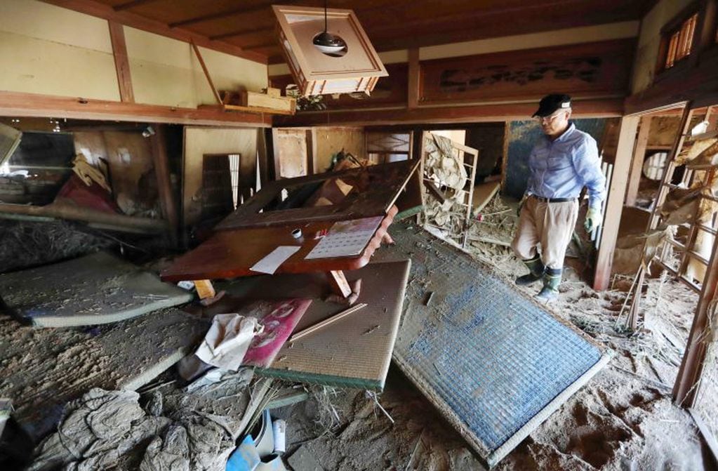 Varios residentes comienzan a retirar los escombros de su casa tras las inundaciones registradas de Kurashiki, Japón.