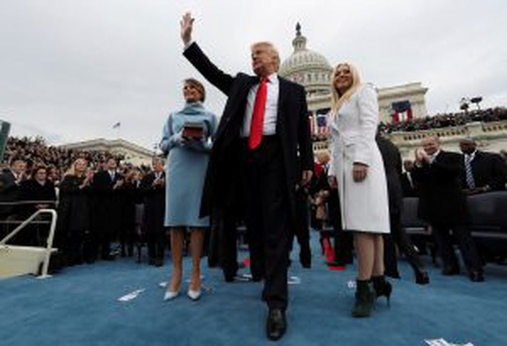U.S. President Donald Trump acknowledges the audience after taking the oath of office as his wife Melania (L) and daughter Tiffany watch during inauguration ceremonies swearing in Trump as the 45th president of the United States on the West front of the U.S. Capitol in Washington, DC, U.S., January 20, 2017.  REUTERS/Jim Bourg   TPX IMAGES OF THE DAY