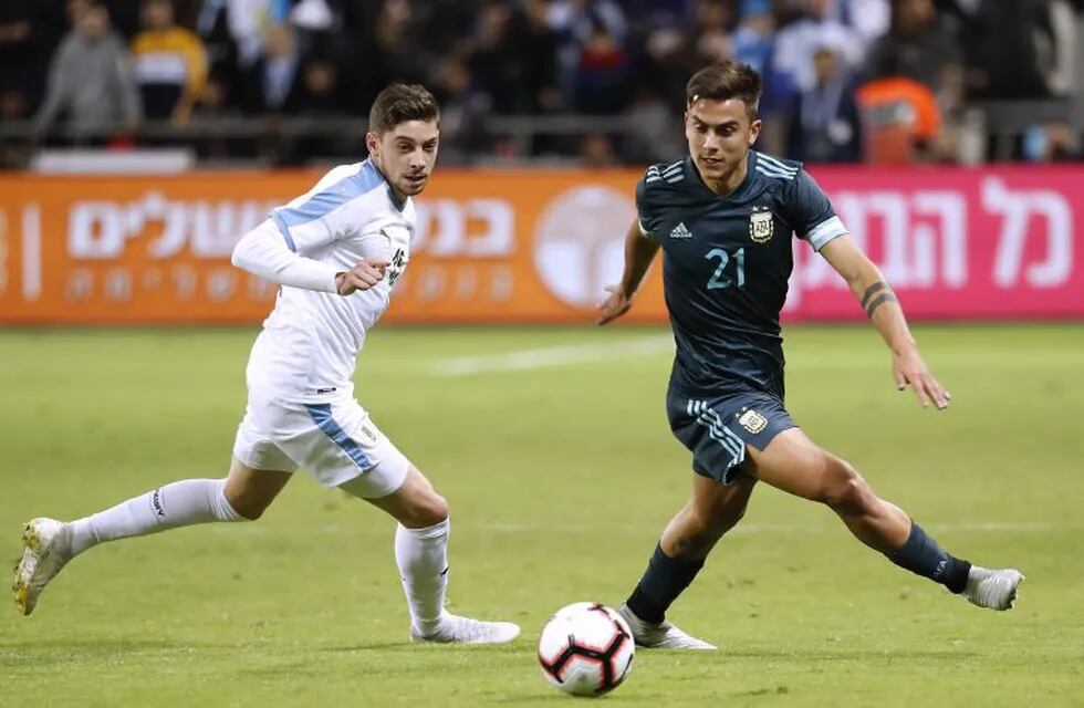 Uruguay's midfielder Federico Valverde fights for the ball with Argentina's forward Paulo Dybala during the friendly football match between Argentina and Uruguay at the Bloomfield stadium in the Israeli coastal city of Tel Aviv on November 18, 2019. (Photo by EMMANUEL DUNAND / AFP)