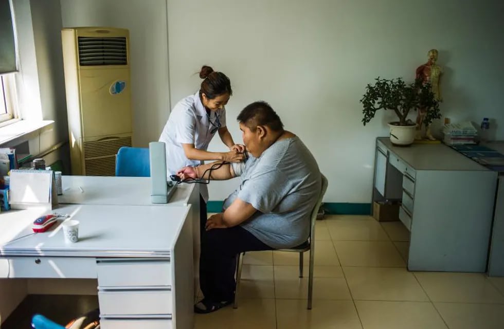 investigadores dieron la alarma sobre una explosión de obesidad entre los niu00f1os en zonas rurales de China rnrn(FILES) This file photo taken on May 25, 2015 shows a nurse taking the blood pressure of an overweight youth during his acupuncture and exercise treatment at the Aimin (Love the People) Fat Reduction Hospital in the northern port city of Tianjin.   Researchers raised the alarm April 27, 2016 about an obesity explosion among children in rural China as a Western-style diet high in sugar and carbohydrates starts taking its toll. A 29-year survey of kids in China's eastern Shandong province revealed that 17 percent of boys younger than 19 were obese in 2014, and nine percent of girls -- up from under one percent for both genders in 1985. / AFP / FRED DUFOURrn china Tianjin  joven con sobrepeso acupuntura y el tratamiento en el Aimin el amor del pueblo Hospital de reduccion de grasas