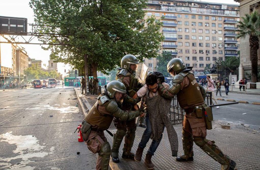 Miembros de la policía detienen a un hombre durante las protestas en Santiago, Chile (Foto: AP Photo/Esteban Felix)