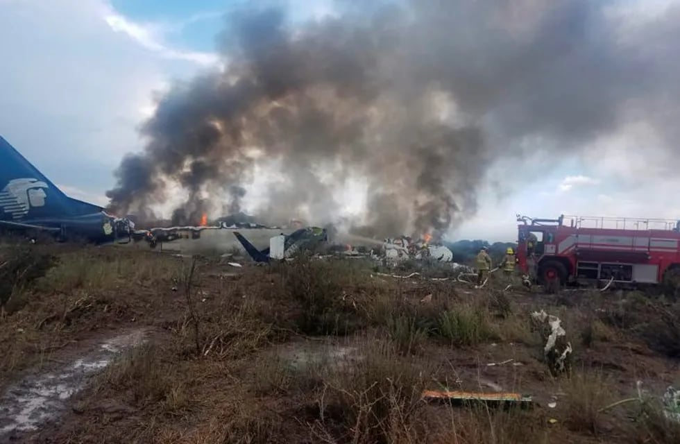 Los bomberos intentan apagar el fuego en el avión de la compañía Aeroméxico.
