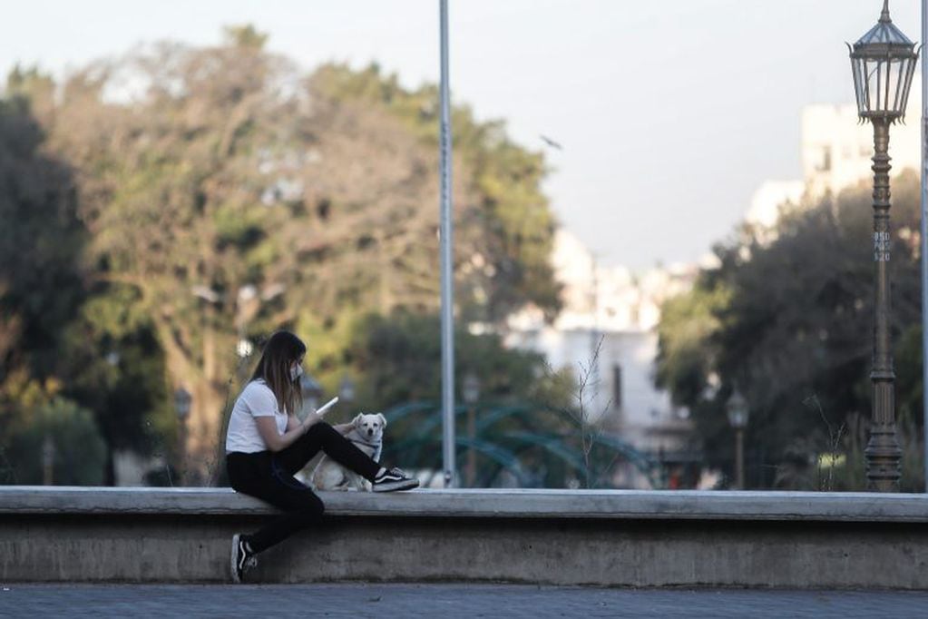 Una mujer mira su celular en un parque este sábado, durante el primer día en el cual se permiten salidas recreativas para menores, en Buenos Aires (Argentina). (Foto: EFE/ Juan Ignacio Roncoroni)