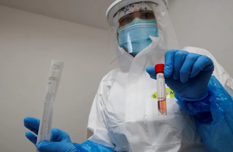 A healthcare worker, wearing a protective suit and a face mask, holds a test tube after administering a nasal swab in the medical center in Positano, as Italy eases some of the lockdown measures put in place during the coronavirus disease (COVID-19) outbreak, in Positano, Italy, May 22, 2020. REUTERS/Ciro De Luca