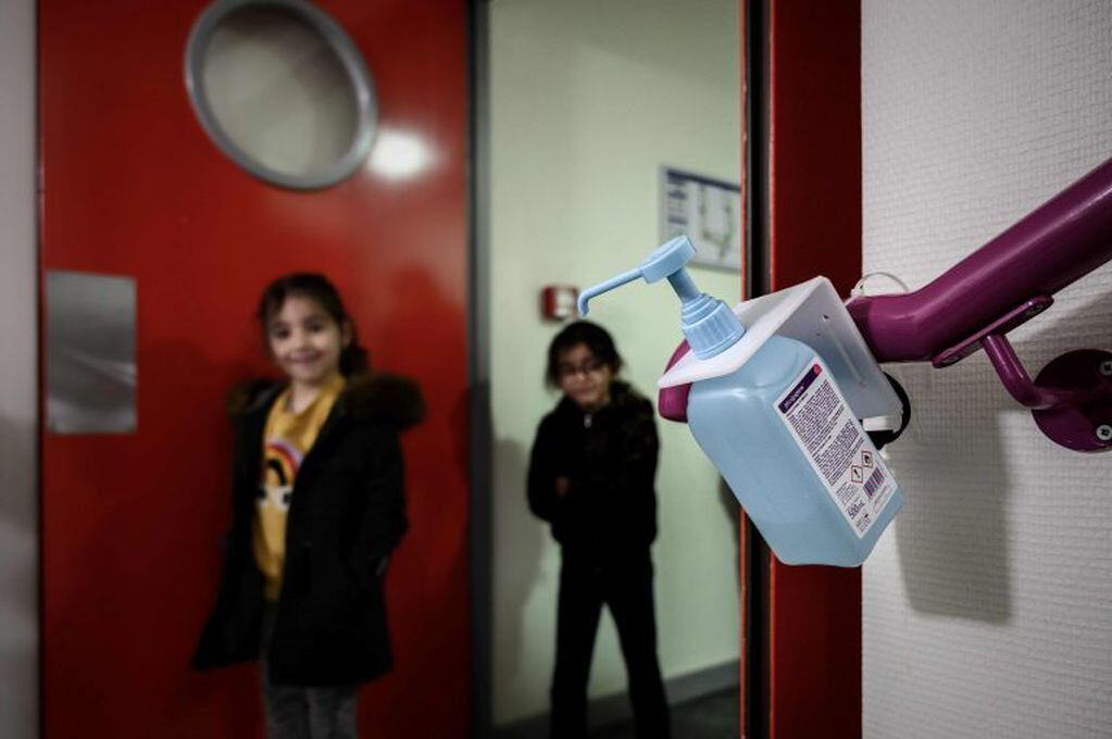 Los niños se desinfectan las manos con alcohol en gel antes de entrar al aula. (Foto: AFP)