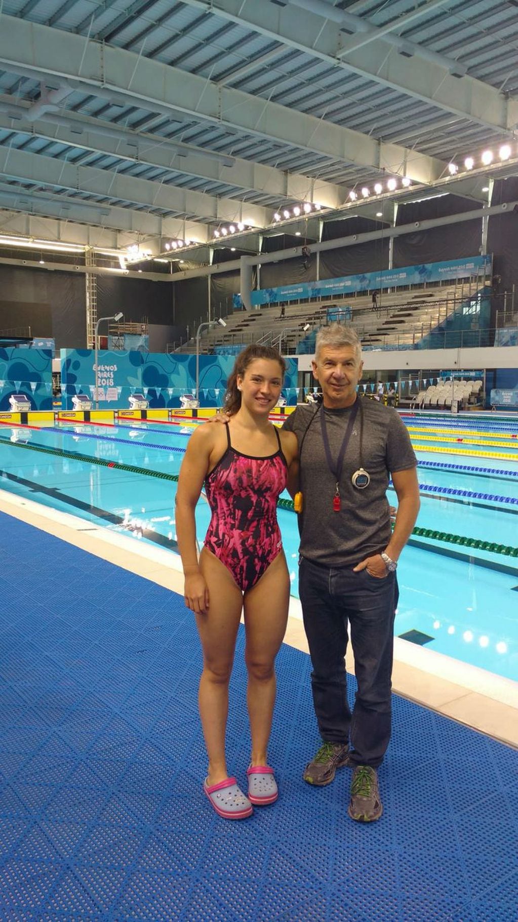 Héctor Bochi Sosa junto a Delfina Dini, la nadadora cordobesa que consiguió dos diplomas olímpicos en Buenos Aires 2018.