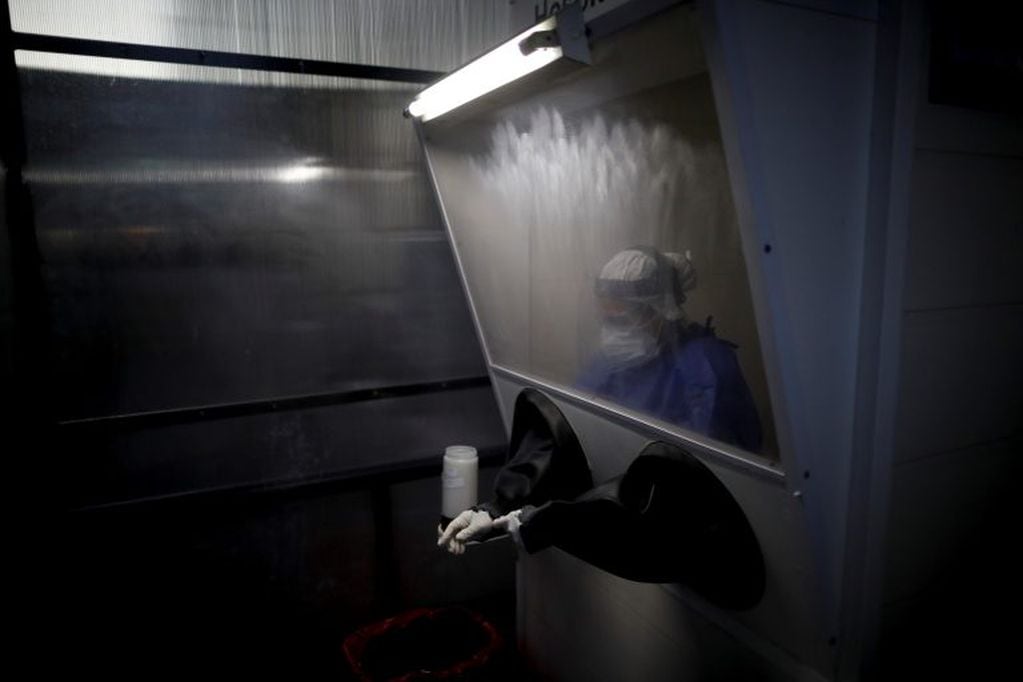 A healthcare worker prepares to conduct a nasal swab test for COVID-19 from inside a freestanding coronavirus testing isolation booth at a hospital in Buenos Aires, Argentina, Monday, Sept. 21, 2020. (AP Photo/Natacha Pisarenko)