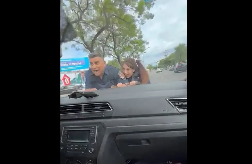 Policías. El gesto de los uniformados siendo arrastrados por el auto. (Captura de video)