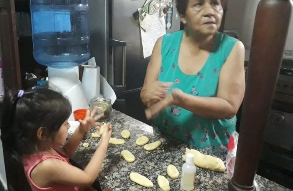 Laura Zalazar con su nieta, armando ofrendas con masa de pan.