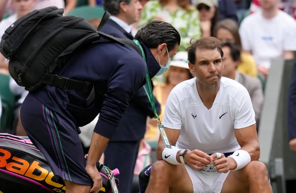 "Rafa" recibe asistencia en el banco. Con fisio y antiinflamatorios logró relajar la zona para terminar su partido de cuartos de final en Wimbledon.